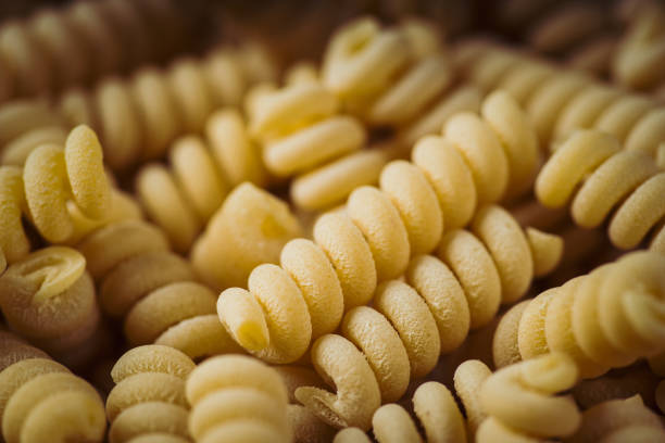 Background with raw dry fusilli bucati pasta