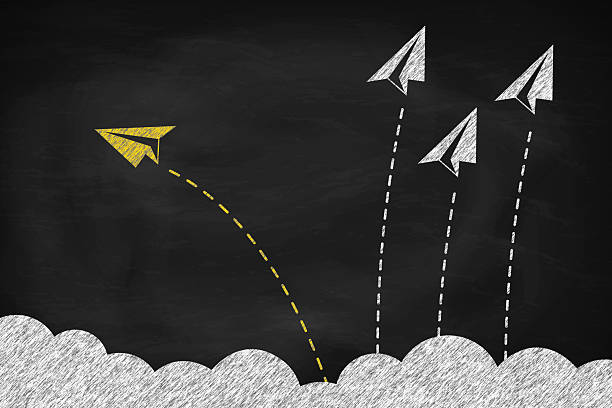 istock Individual and yellow paper plane changing direction around the clouds on black chalkboard 2205976166