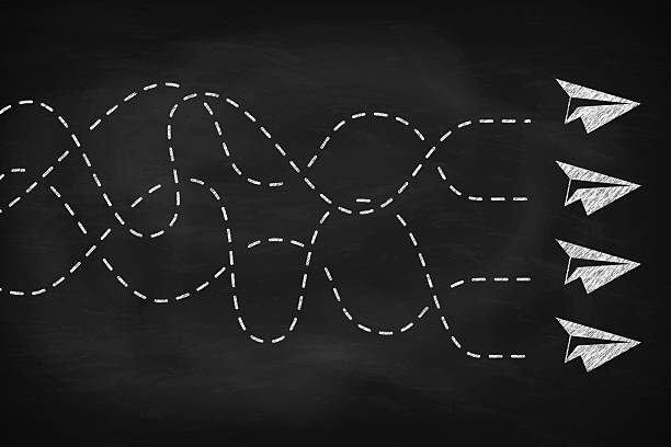 istock Group of paper plane flying different directions on black chalkboard. 2205976168