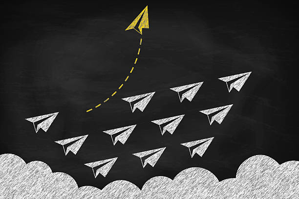 istock Think differently concept. Creative idea for new business. Yellow paper plane changing direction on black chalkboard 2205976256