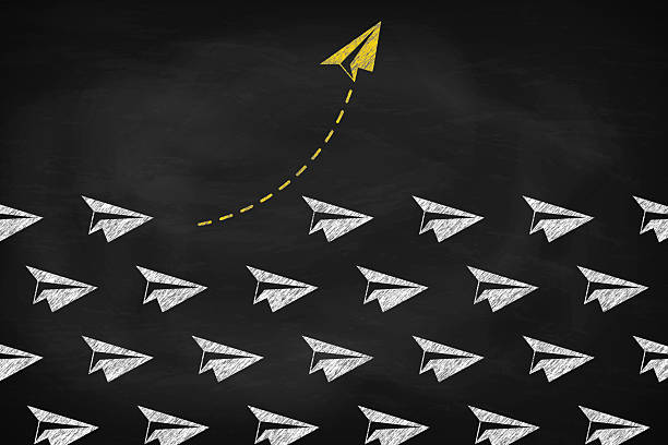 istock Yellow paper plane changing direction on black chalkboard. Think differently concept 2205976285