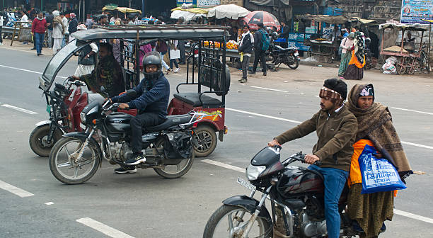 Delhi - India - February 3, 2025: Busy Indian street scene with rickshaw and motorbikes.