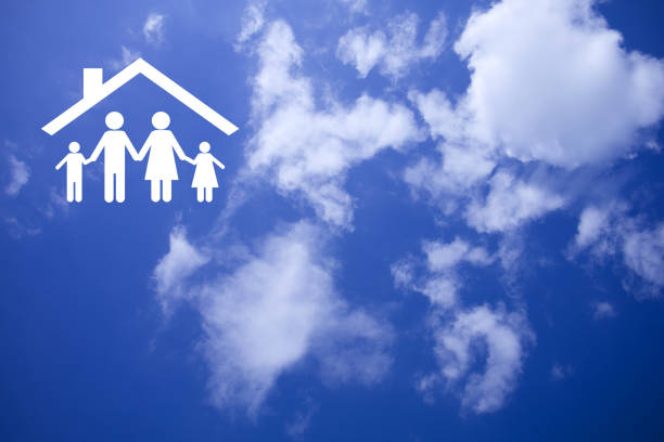 Family symbol with parents and children on hands of insurance agent looking out window view with several houses and sunset, concept of life insurance and health insurance for family