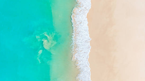 istock Turquoise ocean waves rolling onto a white sandy shore in this breathtaking aerial beach view. summer background and summer holiday concept. 2205980734