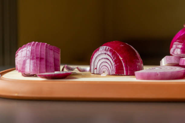 sliced red onions on cutting board dark background close-up