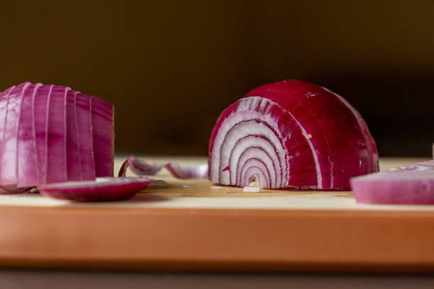sliced red onions on cutting board dark background close-up