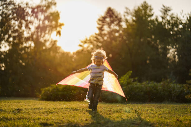 istock Boy having fun playing whit kite outdoors 2205992359