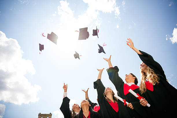 istock Jubilant graduates celebrating outdoors, tossing mortarboards into the sky, marking the completion of their academic journey on sunny day. 2205993610