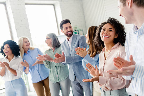 istock Smiling professionals applauding together indoors in a corporate environment showcasing teamwork and collaboration 2206001692
