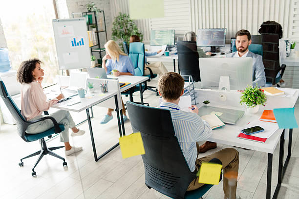 istock Colleagues Collaborating in a Modern Office Workspace with Daylight and Relaxed Atmosphere 2206001804