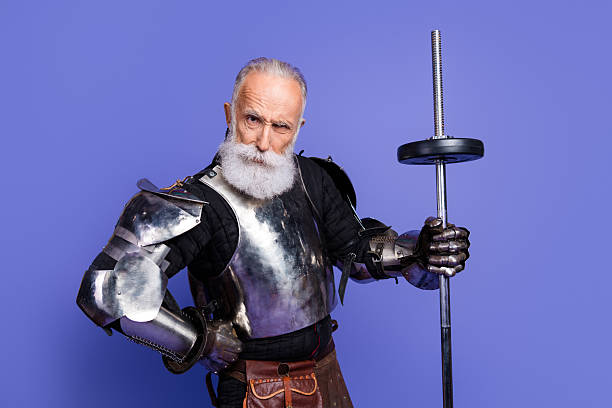 istock Mature man in medieval knight armor with vibrant beard posing against violet background 2206003712