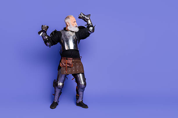 istock Elderly armored knight cheering energetically on a vibrant purple background, showcasing historical and medieval elements 2206003743