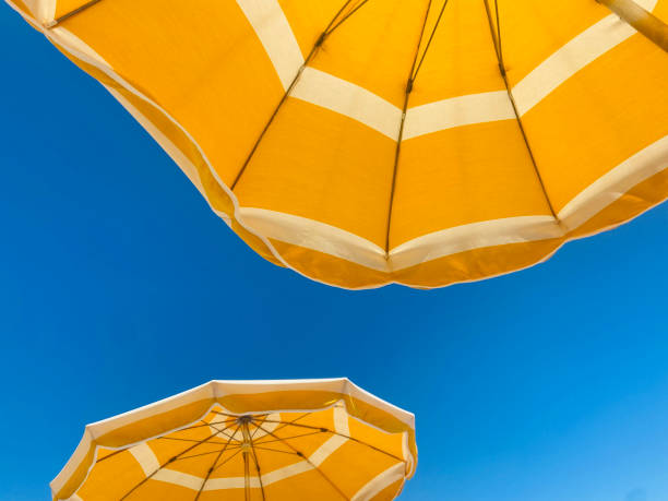 istock Yellow beach umbrellas against a bright blue sky 2206003977