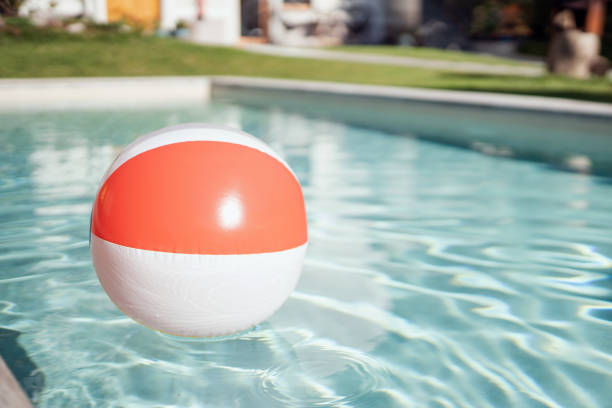 A vibrant beach ball floats in a serene pool at a tourist resort, capturing the essence of summer and relaxation. Perfect for concepts of vacation, leisure, and carefree lifestyle.