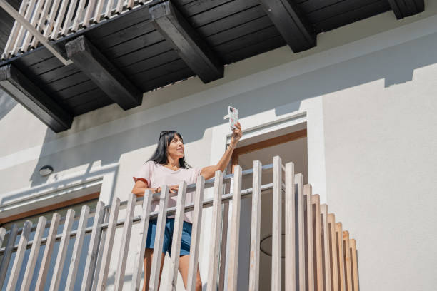 istock Hispanic Woman Enjoying Vacation Selfie on Balcony 2206005105