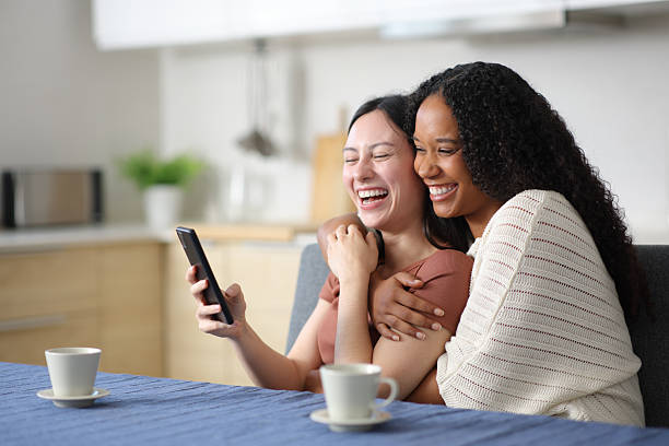 istock Happy interracial lesbian couple using smart phone 2206005272