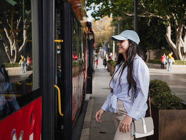 istock Young woman smiling while boarding a city bus 2206008229