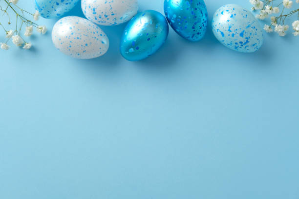 istock Blue and white speckled Easter eggs with white flowers on a light blue background. Flat lay, top view, copy space 2206009136