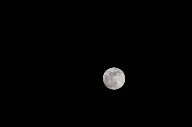 A high-resolution photograph of the waxing gibbous moon against a deep black night sky. The surface details, including craters and lunar maria, are clearly visible. The simplicity of the composition highlights the celestial beauty and vastness of space.