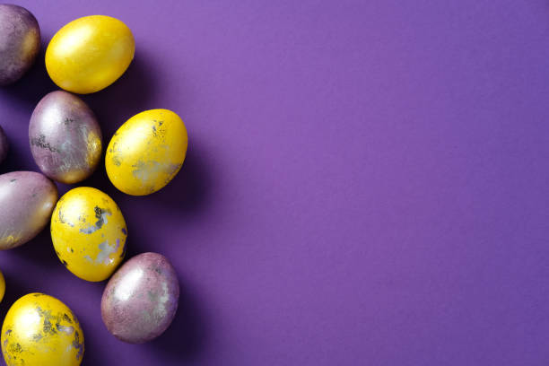 istock Happy Easter flat lay with violet and golden Easter eggs on purple background. Top view with copy space. Minimal style 2206010633