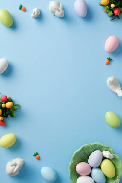 istock Easter frame. Top view pastel colored Easter eggs, bunnies, carrots, decorations on pastel blue background. 2206011669