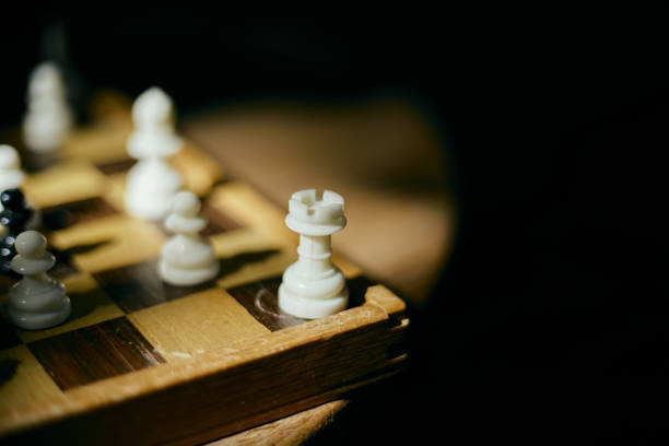 White and black chess pieces on chess board, selective focus