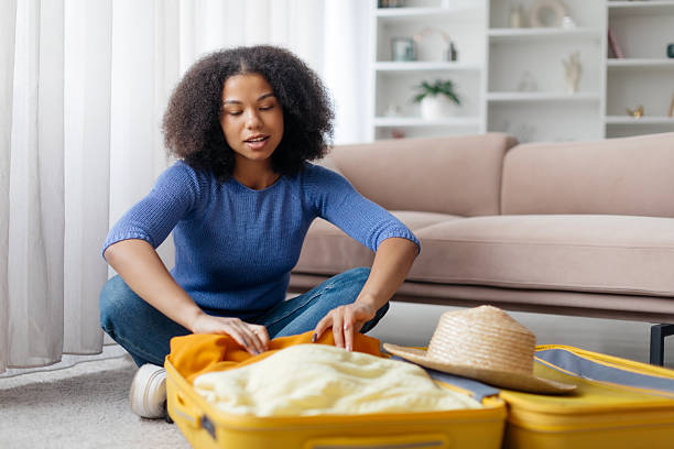 istock Young woman packing her yellow suitcase at home, getting ready for trip 2206013786