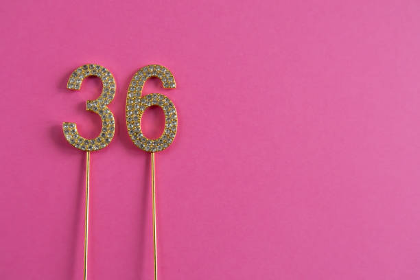 istock Golden number 36 cake toppers on pink background 2206014683