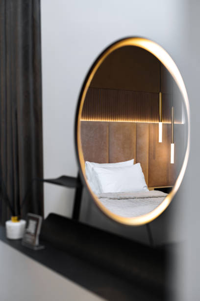Contemporary bedroom interior with soft lighting reflected in a round mirror