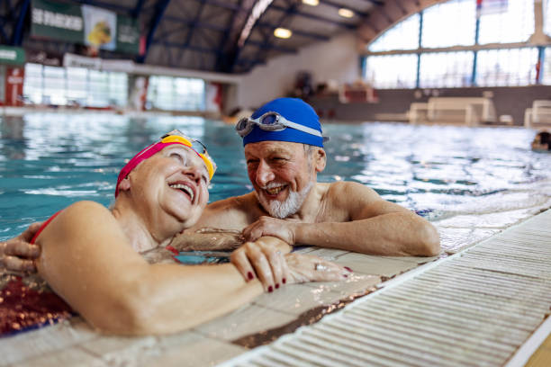 istock Elderly Couple Smiling in Swimming Pool During Recreational Activity 2206015949