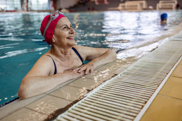 istock Senior Woman Smiling While Relaxing in a Swimming Pool Facility 2206015990