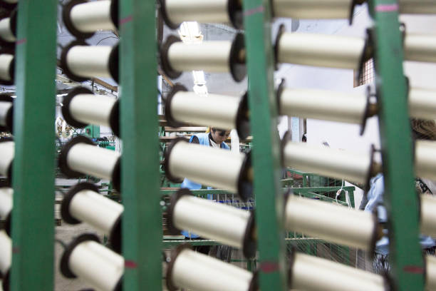 Many spools of silk thread. Weaving machine. Close-up