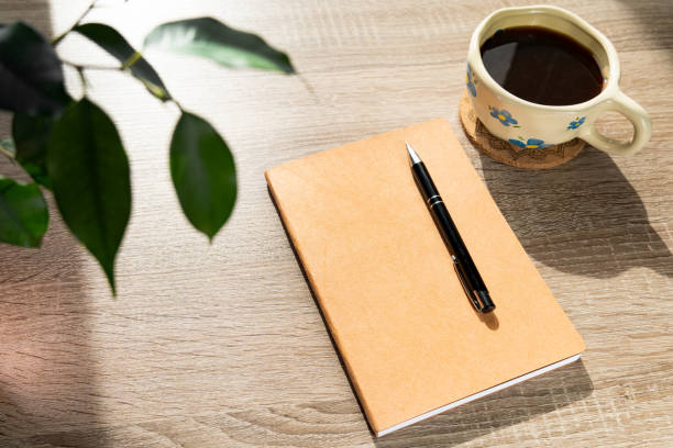 istock Cozy Workspace with a Notebook, Coffee Cup, and Potted Plant 2206023341
