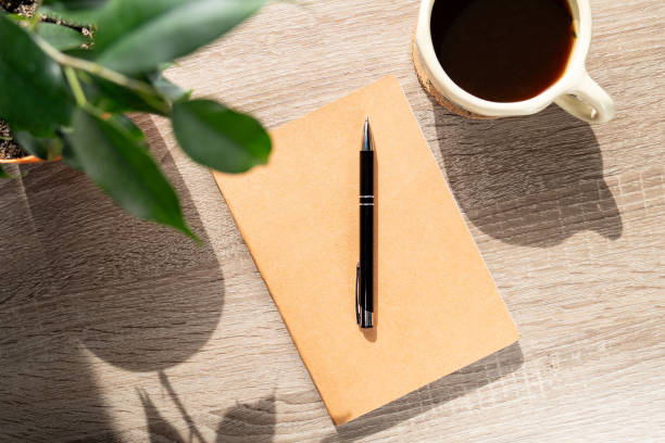 istock Cozy Workspace with a Notebook, Coffee Cup, and Potted Plant 2206023357