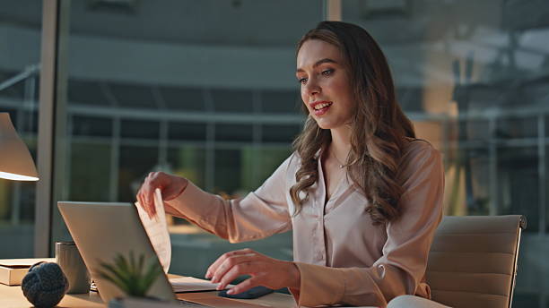 istock Smiling businesswoman reviewing documents in evening office. Closeup it manager 2206027092