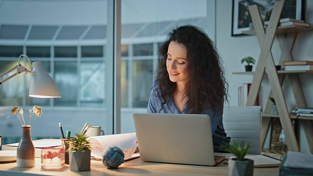 istock Smiling woman reading documents in modern office. Professional reviewing papers 2206031486
