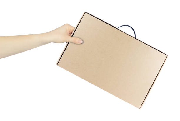istock cardboard suitcase, brown cardboard box for laptop computer in hand, outstretched hand with cardboard suitcase isolated from background 2206033192