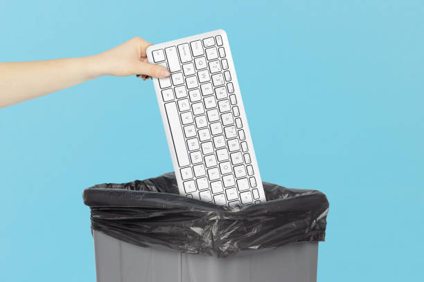 istock throw keyboard in trash can, keyboard in hand in front of trash can 2206033238
