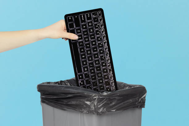 istock throw keyboard in trash can, keyboard in hand in front of trash can 2206033243