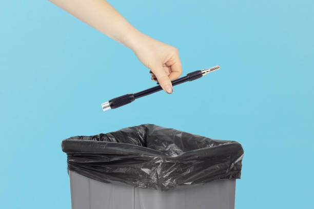 istock throw flexible screwdriver bit in trash can, bendable screwdriver bit in hand in front of trash can 2206033302