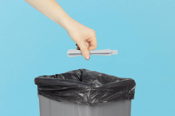 istock throw plastic spatula for disassembling the case of phones and laptops into trash bin, plastic spatula in hand in front of trash bin, plastic recycling concept 2206033336