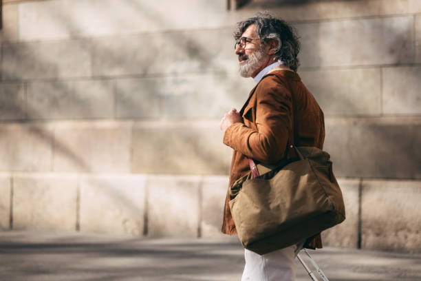 istock Man With Bag Walking Outdoors, Wearing Smart Casual Outfit in Urban Setting 2206033797