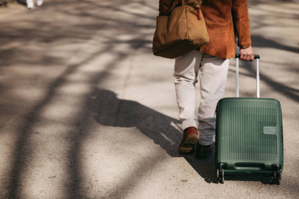 istock Traveler Walking With Suitcase Outdoors in Bright Natural Setting 2206033826