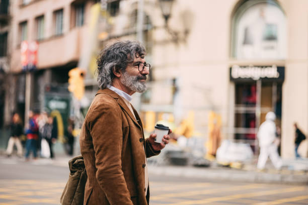 istock Mature Man Walking City Streets Holding Takeaway Coffee Cup 2206033864