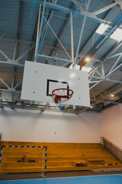 istock Basketball hoop hanging in empty gymnasium with epoxy floor 2206035375