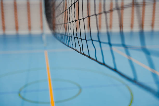 istock Volleyball net hanging over blue epoxy floor in gym 2206035386