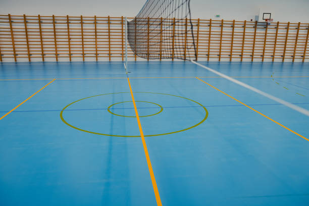 istock Volleyball net stands on blue epoxy floor in empty gym 2206035397