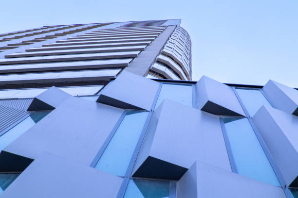 istock Low-angle view of a modern high-rise building with geometric glass and metal facade elements. 2206035714