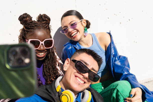 istock Multicultural friends sharing laughter, capturing smartphone selfie during outdoor hangout with genuine happiness and camaraderie 2206037602