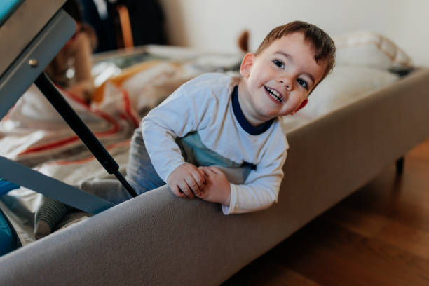 istock Happy toddler playing on bed and smiling at camera 2206039893